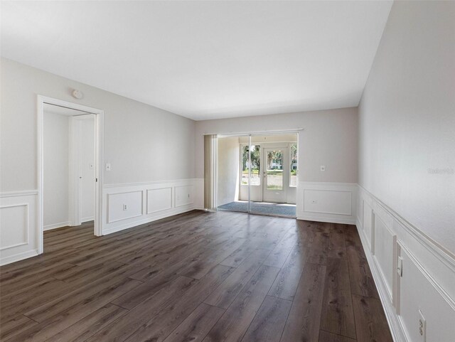 10356 Carrollwood Ln Unit 204, Tampa, FL 33618 - spare room with a decorative wall, wainscoting, dark wood-style floors, and a smoke detector