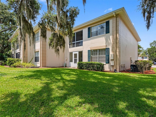 10356 Carrollwood Ln Unit 204, Tampa, FL 33618 - rear view of house with stucco siding and a lawn