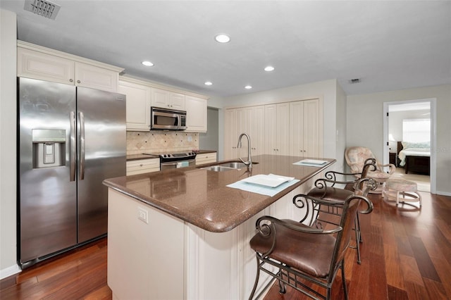 14341 Passage Way, Seminole, FL 33776 - kitchen featuring appliances with stainless steel finishes, a sink, dark wood-style flooring, decorative backsplash, and recessed lighting