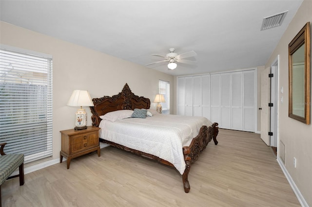 14341 Passage Way, Seminole, FL 33776 - bedroom featuring light wood-style flooring, baseboards, multiple windows, and a ceiling fan