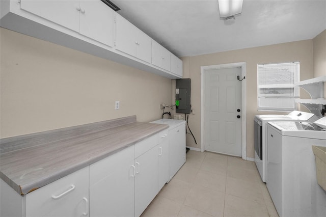 14341 Passage Way, Seminole, FL 33776 - laundry area featuring electric panel, washing machine and clothes dryer, cabinet space, light tile patterned flooring, and baseboards