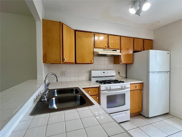 1510 Mission Hills Blvd Unit 19-F, Clearwater, FL 33759 - kitchen with under cabinet range hood, white appliances, a sink, tile counters, and brown cabinets