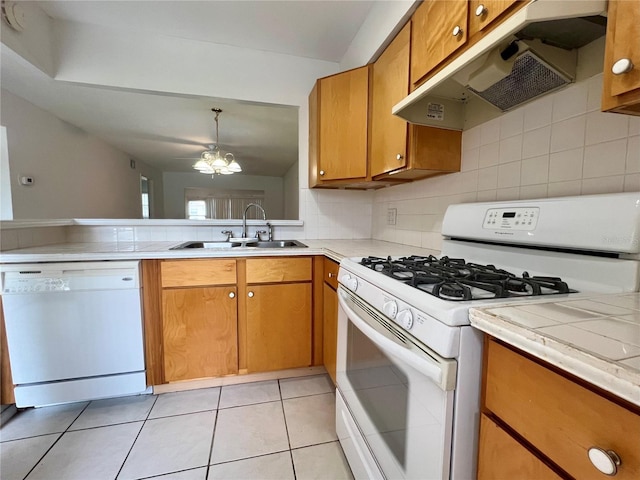 1510 Mission Hills Blvd Unit 19-F, Clearwater, FL 33759 - kitchen featuring white appliances, under cabinet range hood, a sink, and light countertops