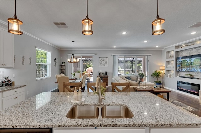 5026 Bromeliad Ave, Wimauma, FL 33598 - kitchen with a sink, open floor plan, crown molding, wood finished floors, and a center island with sink