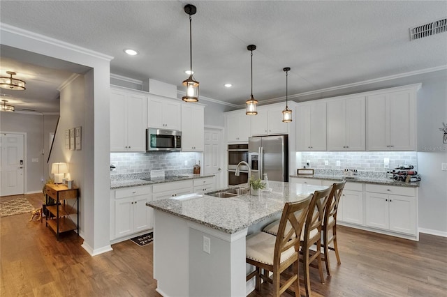5026 Bromeliad Ave, Wimauma, FL 33598 - kitchen with stainless steel appliances, a sink, ornamental molding, decorative backsplash, and dark wood-type flooring