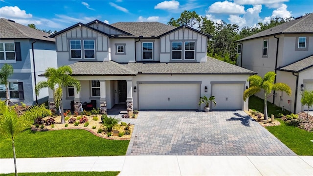 5026 Bromeliad Ave, Wimauma, FL 33598 - view of front of home with decorative driveway, roof with shingles, stucco siding, a front yard, and a garage
