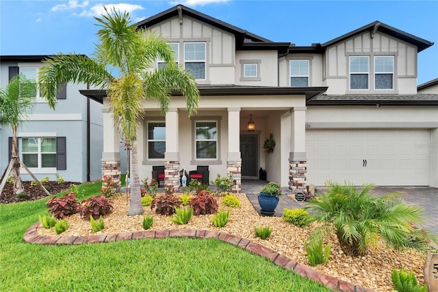 5026 Bromeliad Ave, Wimauma, FL 33598 - view of front of house featuring stucco siding, a garage, covered porch, driveway, and board and batten siding