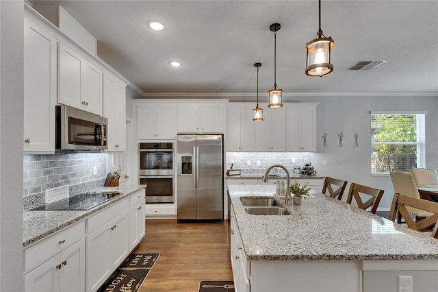 5026 Bromeliad Ave, Wimauma, FL 33598 - kitchen featuring stainless steel appliances, a sink, decorative backsplash, white cabinets, and ornamental molding