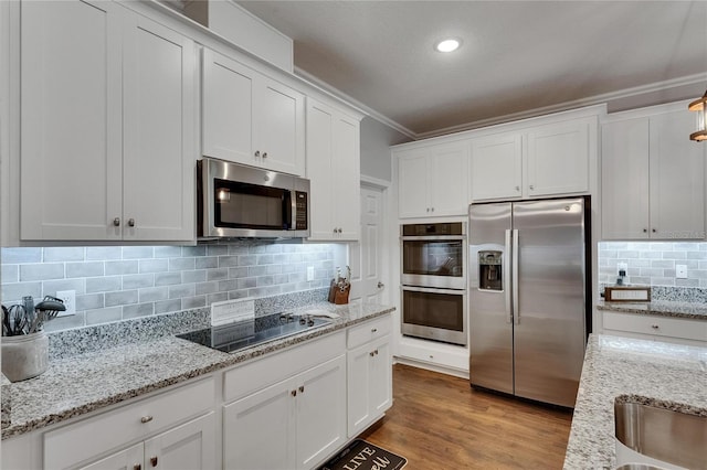 5026 Bromeliad Ave, Wimauma, FL 33598 - kitchen with stainless steel appliances, white cabinets, crown molding, tasteful backsplash, and light stone counters