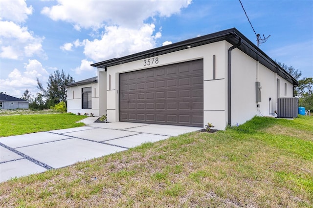 3578 NE 9th Pl, Cape Coral, FL 33909 - view of front facade with stucco siding, central AC, a front lawn, concrete driveway, and an attached garage