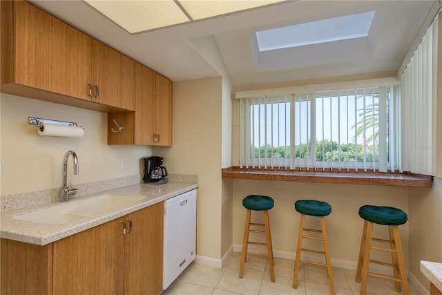1500 Sunset Rd Unit C10, Tarpon Springs, FL 34689 - kitchen featuring white dishwasher, a kitchen breakfast bar, a skylight, and light stone counters