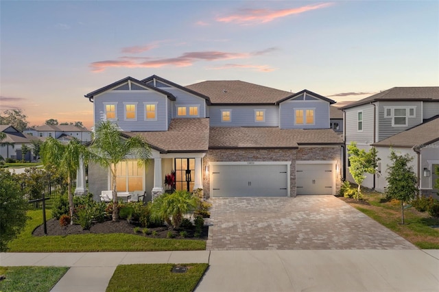 13859 Sharp Hawk Dr, Riverview, FL 33569 - view of front of house with a shingled roof, an attached garage, driveway, and stone siding