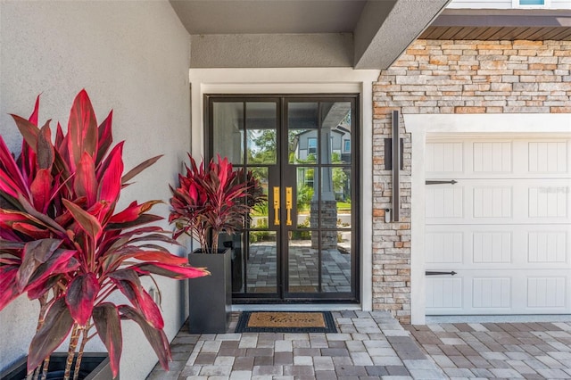 13859 Sharp Hawk Dr, Riverview, FL 33569 - view of exterior entry with french doors, stucco siding, and stone siding