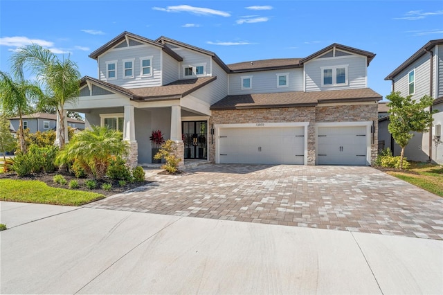 13859 Sharp Hawk Dr, Riverview, FL 33569 - craftsman-style home with a garage, decorative driveway, stone siding, a porch, and a shingled roof