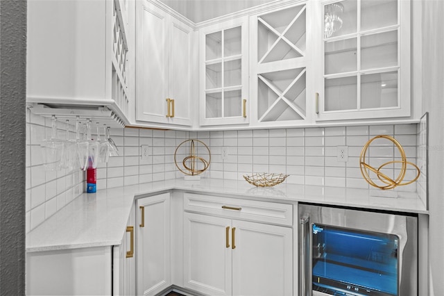 13859 Sharp Hawk Dr, Riverview, FL 33569 - kitchen with beverage cooler, backsplash, white cabinetry, glass insert cabinets, and light stone counters