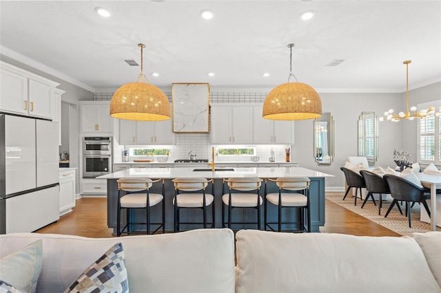 13859 Sharp Hawk Dr, Riverview, FL 33569 - kitchen featuring white refrigerator, double oven, light countertops, crown molding, and white cabinets