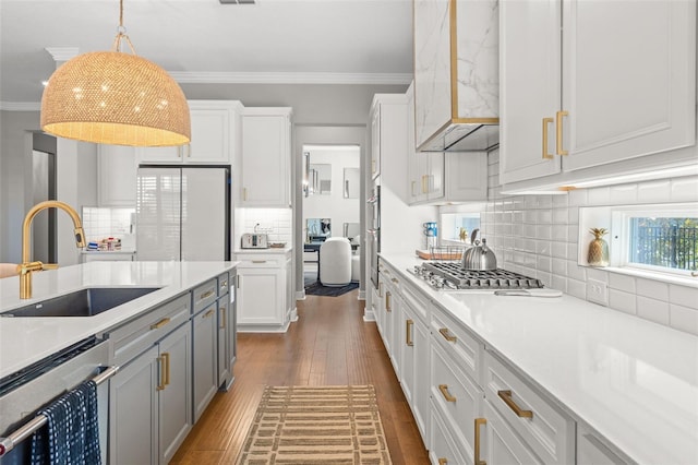 13859 Sharp Hawk Dr, Riverview, FL 33569 - kitchen with a sink, stainless steel appliances, crown molding, dark wood finished floors, and pendant lighting