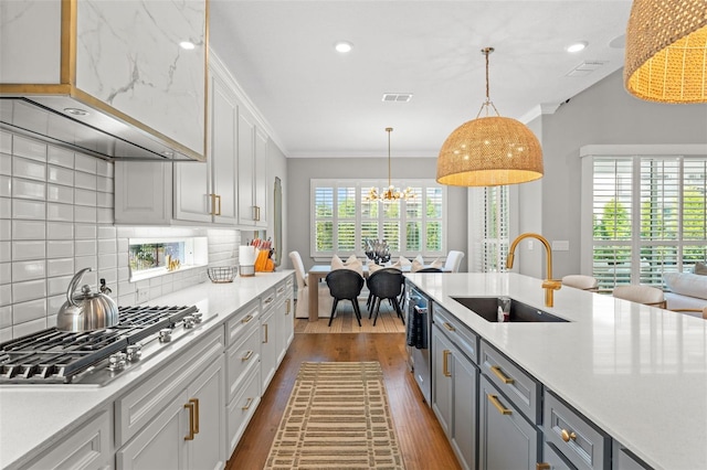 13859 Sharp Hawk Dr, Riverview, FL 33569 - kitchen with a sink, appliances with stainless steel finishes, light countertops, dark wood finished floors, and crown molding
