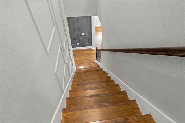 13859 Sharp Hawk Dr, Riverview, FL 33569 - stairway featuring wood finished floors, a textured wall, and baseboards