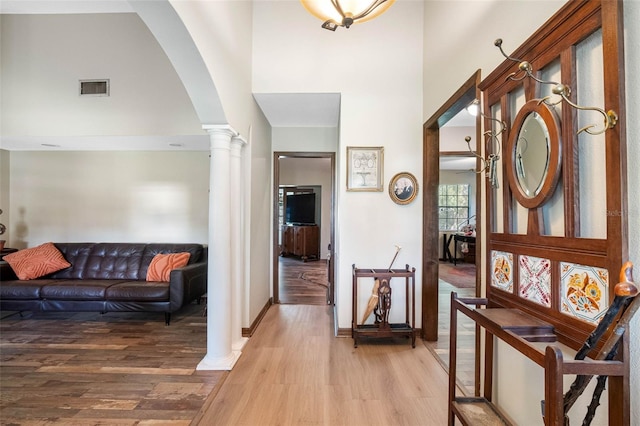 11109 Winn Rd, Riverview, FL 33569 - foyer entrance with a high ceiling, arched walkways, light wood-type flooring, ornate columns, and baseboards