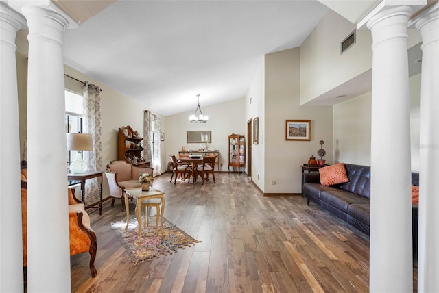 11109 Winn Rd, Riverview, FL 33569 - living area featuring ornate columns, hardwood / wood-style flooring, vaulted ceiling, a chandelier, and baseboards
