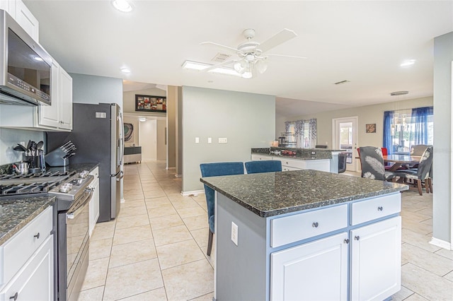 5432 Queen Ave, Spring Hill, FL 34609 - kitchen featuring appliances with stainless steel finishes, a center island, ceiling fan, light tile patterned floors, and white cabinetry