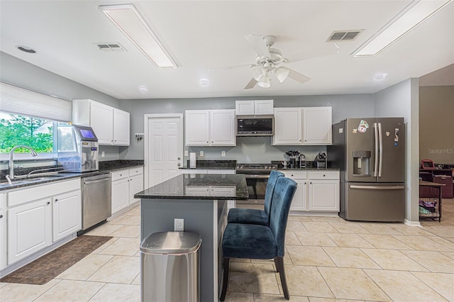5432 Queen Ave, Spring Hill, FL 34609 - kitchen with appliances with stainless steel finishes, a sink, white cabinets, and a kitchen island