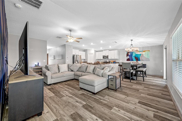 31775 Sun Kettle Loop, Wesley Chapel, FL 33545 - living room with light wood-style floors, a ceiling fan, a chandelier, and baseboards