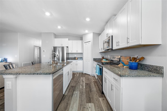 31775 Sun Kettle Loop, Wesley Chapel, FL 33545 - kitchen with appliances with stainless steel finishes, dark wood-style flooring, a sink, recessed lighting, and a kitchen island with sink