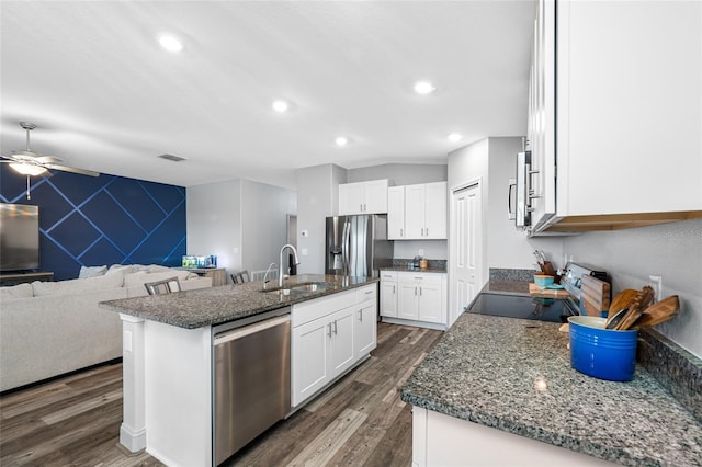 31775 Sun Kettle Loop, Wesley Chapel, FL 33545 - kitchen featuring stainless steel appliances, ceiling fan, dark wood-style floors, white cabinets, and a kitchen island with sink