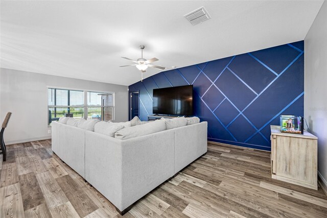 31775 Sun Kettle Loop, Wesley Chapel, FL 33545 - living area featuring an accent wall, ceiling fan, light wood-type flooring, and baseboards