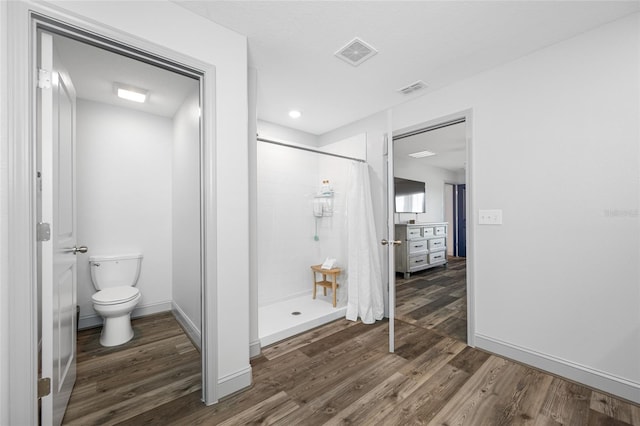 31775 Sun Kettle Loop, Wesley Chapel, FL 33545 - full bathroom featuring wood finished floors, a stall shower, toilet, and baseboards
