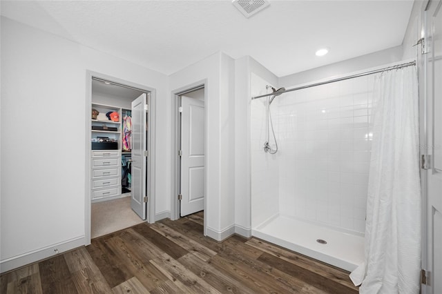31775 Sun Kettle Loop, Wesley Chapel, FL 33545 - bathroom featuring a shower stall, wood finished floors, a spacious closet, and baseboards