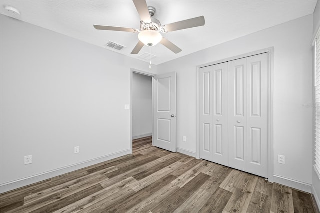 31775 Sun Kettle Loop, Wesley Chapel, FL 33545 - unfurnished bedroom with wood finished floors, a closet, ceiling fan, and baseboards
