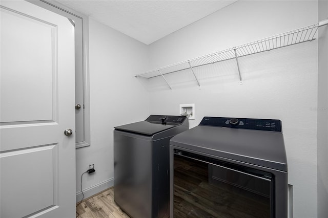 31775 Sun Kettle Loop, Wesley Chapel, FL 33545 - laundry room with washer and clothes dryer, light wood-style floors, and baseboards