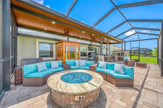 31775 Sun Kettle Loop, Wesley Chapel, FL 33545 - view of patio with an outdoor living space with a fire pit, area for grilling, ceiling fan, and glass enclosure