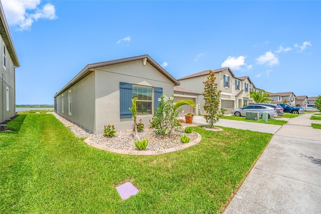 31775 Sun Kettle Loop, Wesley Chapel, FL 33545 - view of front of house featuring stucco siding, concrete driveway, a front yard, and a garage