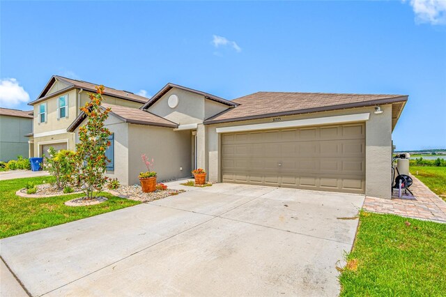 31775 Sun Kettle Loop, Wesley Chapel, FL 33545 - view of front of house with stucco siding, concrete driveway, a garage, and a front lawn