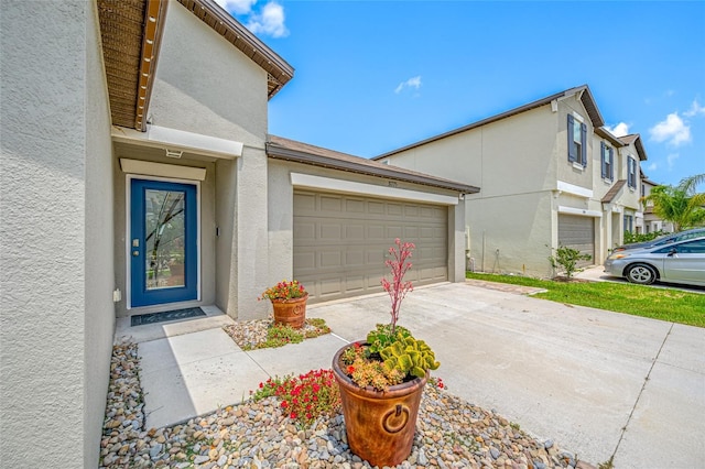 31775 Sun Kettle Loop, Wesley Chapel, FL 33545 - doorway to property featuring stucco siding, concrete driveway, and a garage