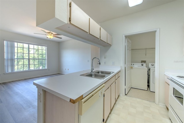 13025 Sanctuary Cove Dr Unit 301, Temple Terrace, FL 33637 - kitchen featuring white appliances, washer and dryer, a sink, light flooring, and a peninsula