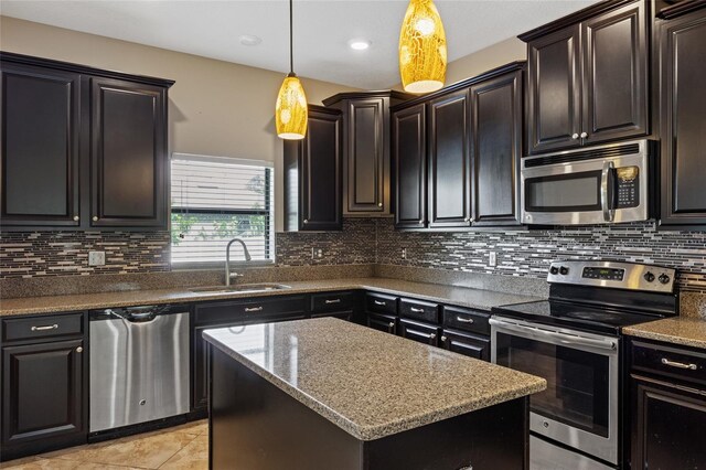 10808 Whitecap Dr, Riverview, FL 33579 - kitchen with appliances with stainless steel finishes, a center island, hanging light fixtures, backsplash, and light tile patterned flooring