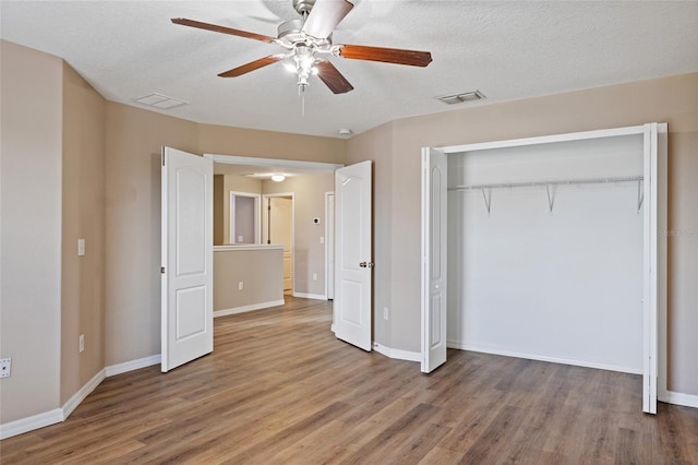 10808 Whitecap Dr, Riverview, FL 33579 - unfurnished bedroom featuring wood finished floors, a closet, a ceiling fan, and a textured ceiling