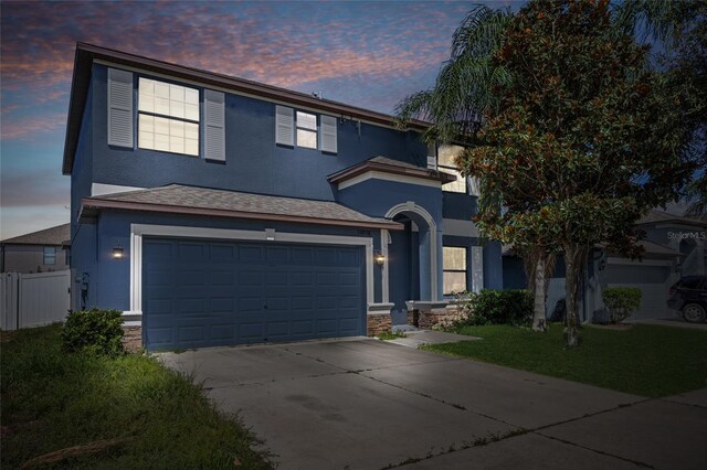10808 Whitecap Dr, Riverview, FL 33579 - view of front of home with stucco siding, concrete driveway, a garage, and stone siding