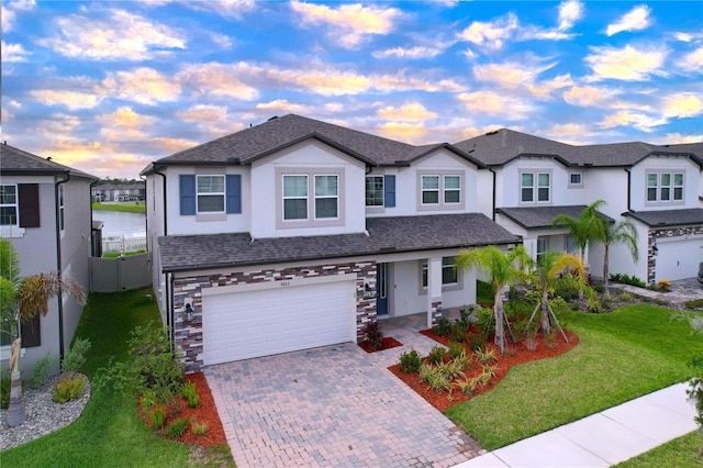 3063 Marine Grass Dr, Wimauma, FL 33598 - view of front of home featuring an attached garage, stucco siding, decorative driveway, a water view, and roof with shingles