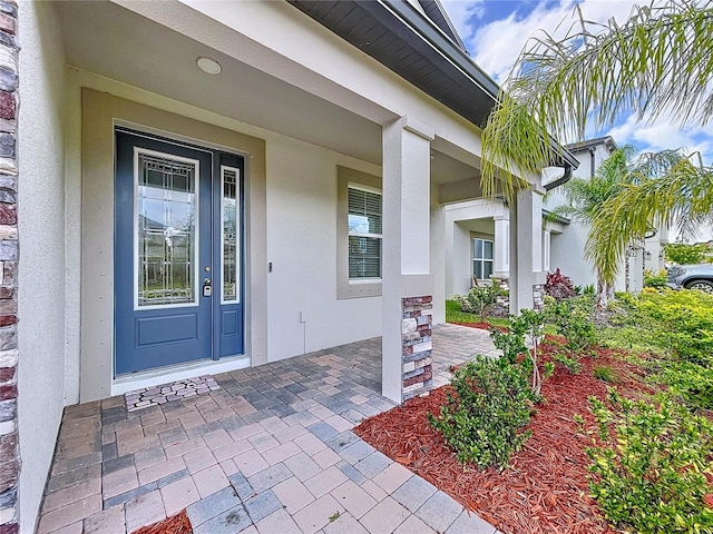 3063 Marine Grass Dr, Wimauma, FL 33598 - view of exterior entry with stucco siding and covered porch