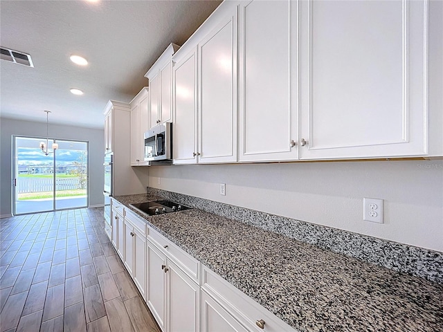 3063 Marine Grass Dr, Wimauma, FL 33598 - kitchen featuring stainless steel appliances, white cabinets, recessed lighting, decorative light fixtures, and a chandelier