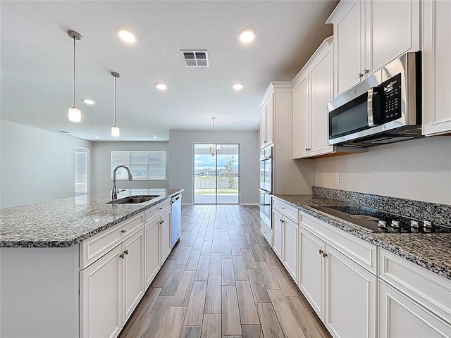 3063 Marine Grass Dr, Wimauma, FL 33598 - kitchen featuring a sink, stainless steel appliances, recessed lighting, white cabinetry, and an island with sink