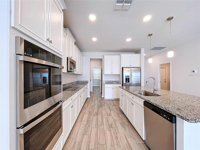3063 Marine Grass Dr, Wimauma, FL 33598 - kitchen featuring stainless steel appliances, a sink, white cabinets, a center island with sink, and recessed lighting
