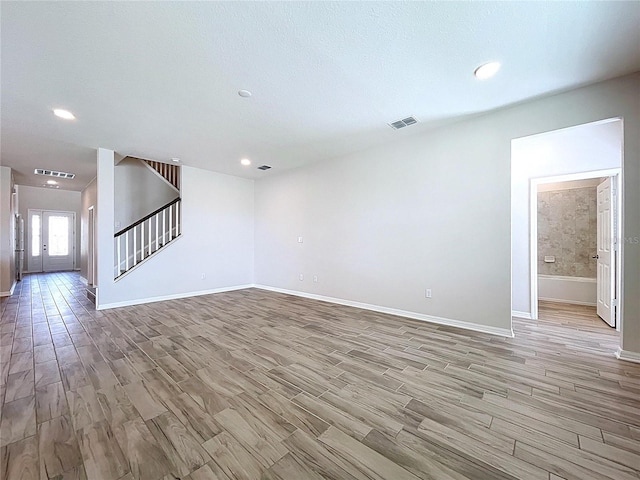 3063 Marine Grass Dr, Wimauma, FL 33598 - unfurnished living room with stairway, baseboards, light wood finished floors, recessed lighting, and french doors