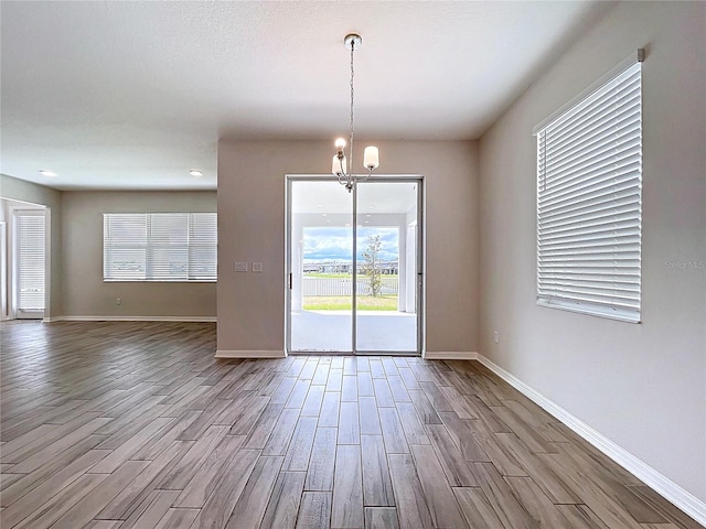 3063 Marine Grass Dr, Wimauma, FL 33598 - spare room with wood finished floors, a chandelier, baseboards, and recessed lighting